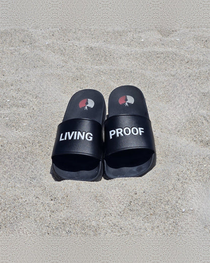 Living Proof slides on sand, LIVING and PROOF printed across the straps