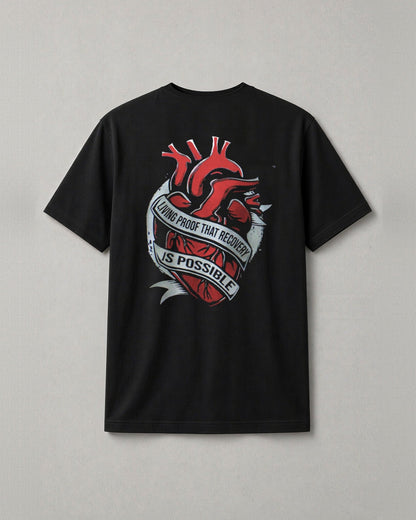 Unchained Heart t-shirt back print: red heart wrapped in a banner reading Living Proof That Recovery Is Possible